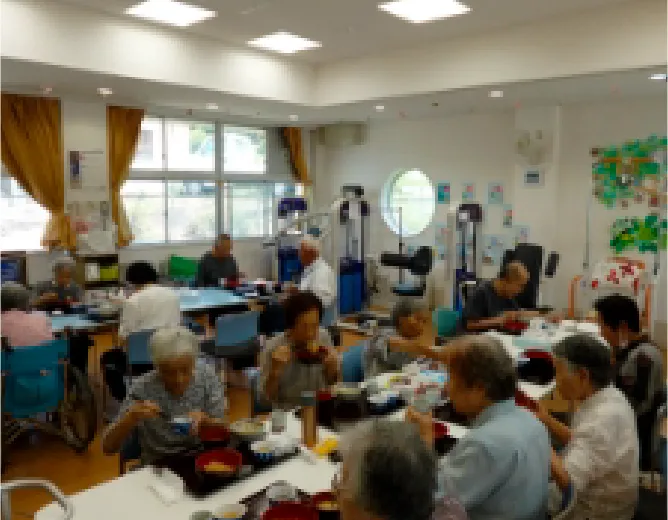 介護施設の食堂で利用者の方々が食事を楽しんでいる和やかな様子