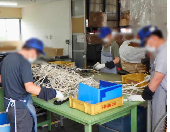 作業場で資材を仕分ける利用者と職員