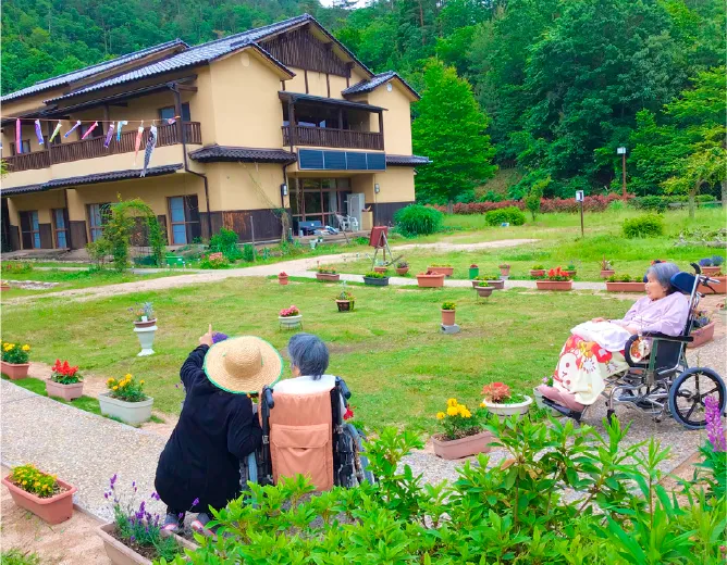 施設前庭で利用者とスタッフが交流する様子