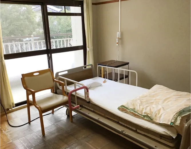 窓際にベッドと椅子が置かれた個室